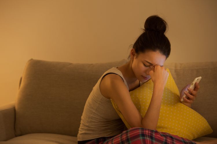 ソファでスマホを見る女性