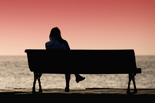 復活愛を願いベンチに座る女性