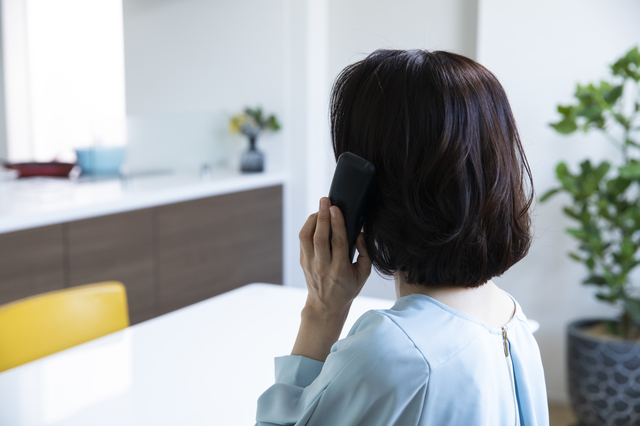 悩みを電話で話す女性