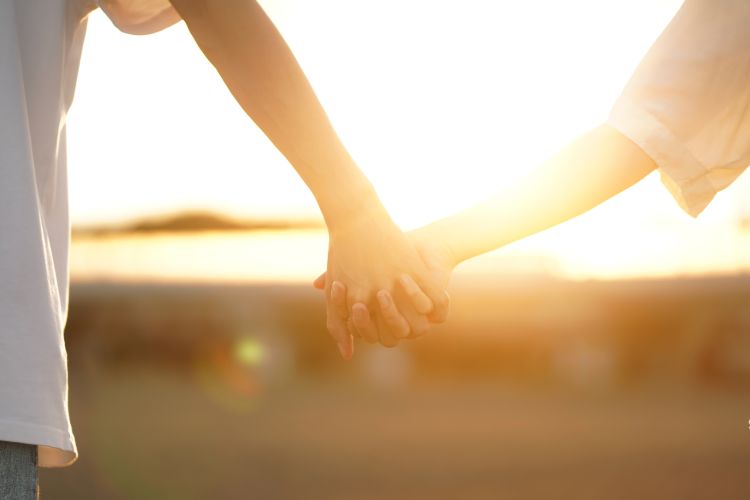 恋人つなぎをする男女