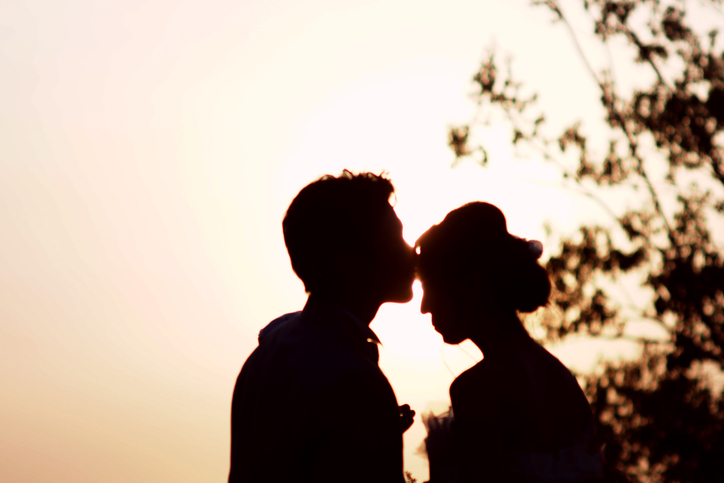 ビーチで結婚式を挙げる男女のシルエット